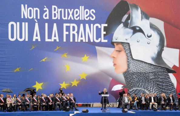 France's far-right National Front (FN) leader Marine Le Pen delivers a speech in front of a poster depicting Joan of Arc (Jeanne d'Arc) and reading "No to Brussels, yes to France" during a May Day rally in Paris on May 1, 2014. AFP PHOTO / PIERRE ANDRIEU (Photo credit should read PIERRE ANDRIEU/AFP/Getty Images)